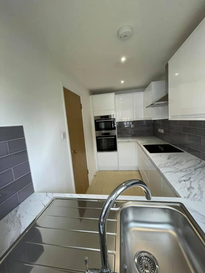 a kitchen with a sink , stove , oven and microwave .