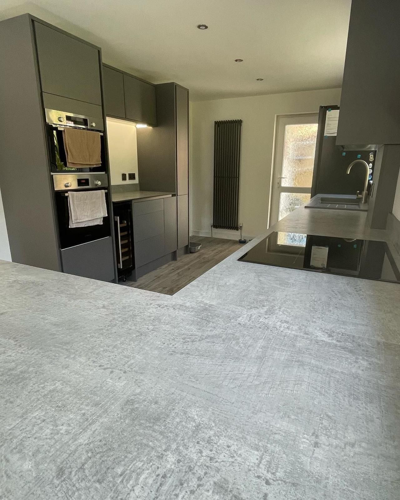 a kitchen with a stove top oven , sink , and cabinets .