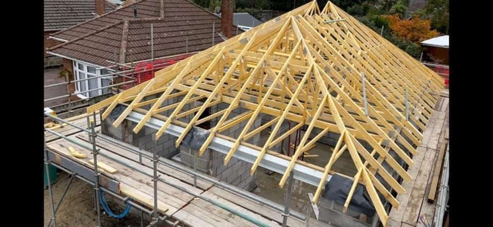 a wooden roof is being built on top of a house .