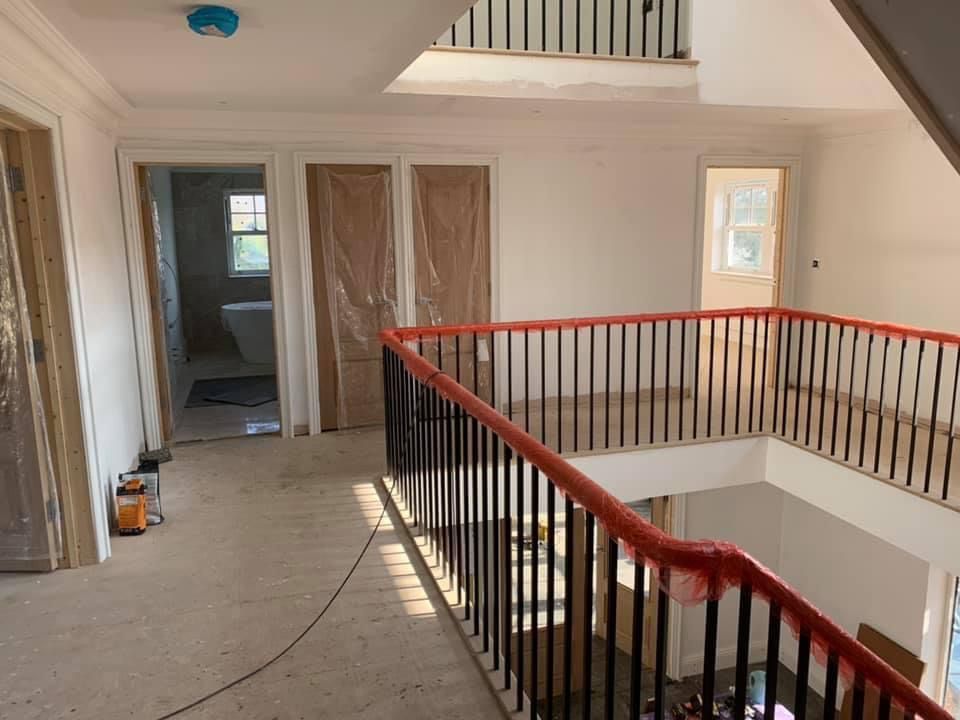 a staircase with a red railing and a vacuum cleaner on the floor .