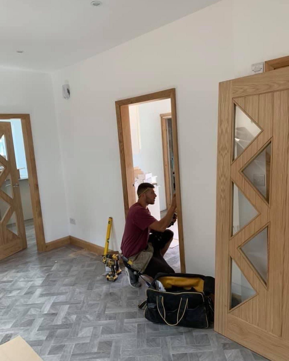 a man is working on a wooden door in a room .