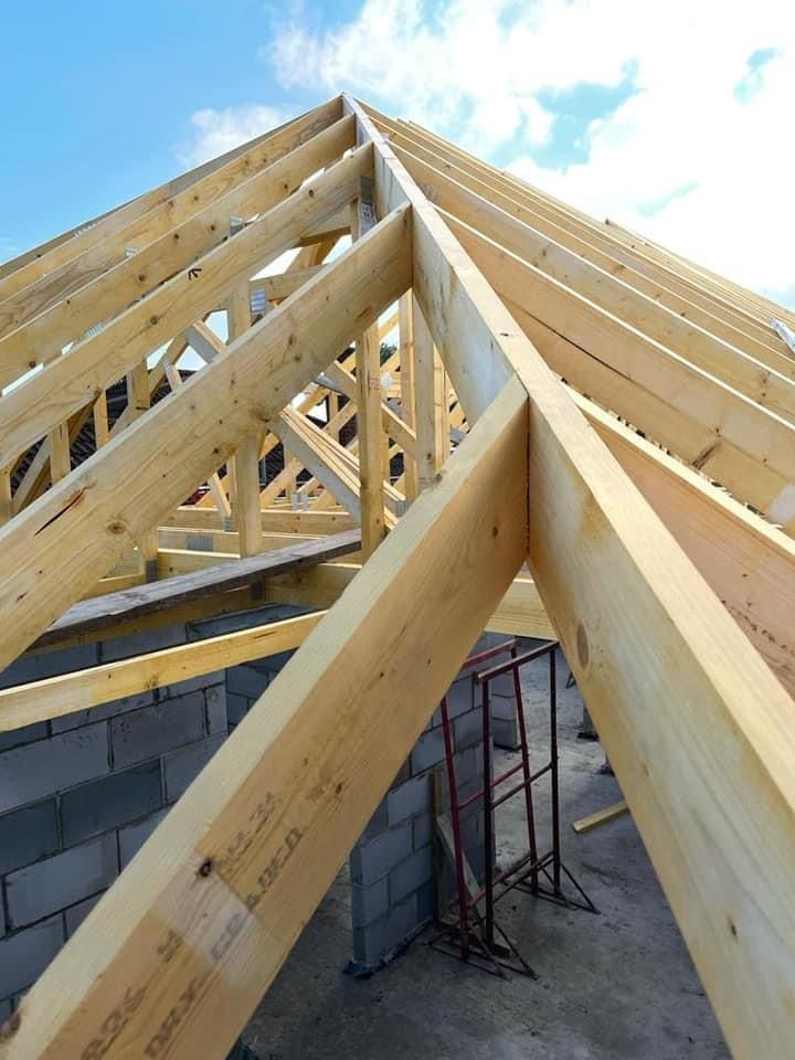 the roof of a building is being built with wooden beams .