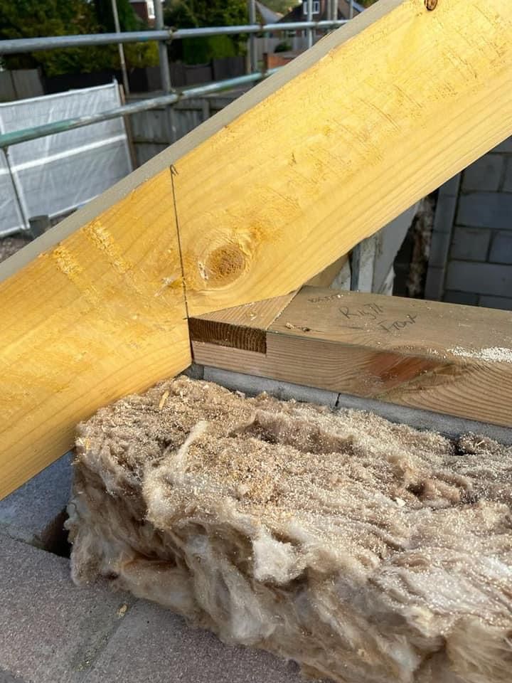 a piece of wood is sitting on top of a pile of wool .