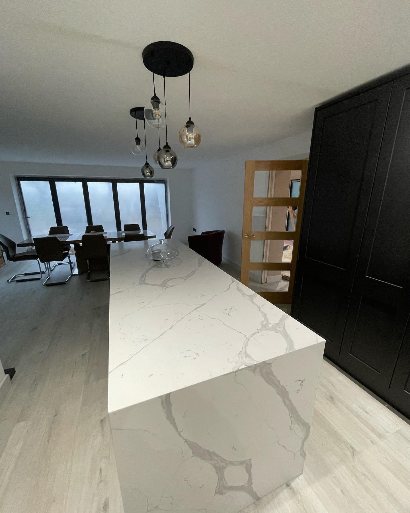 a kitchen with a large white counter top and black cabinets