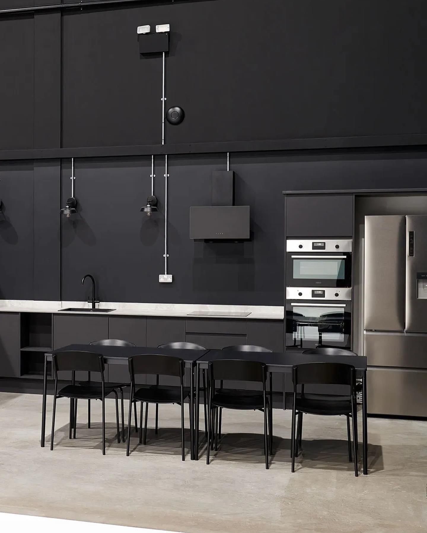 a kitchen with black walls and stainless steel appliances