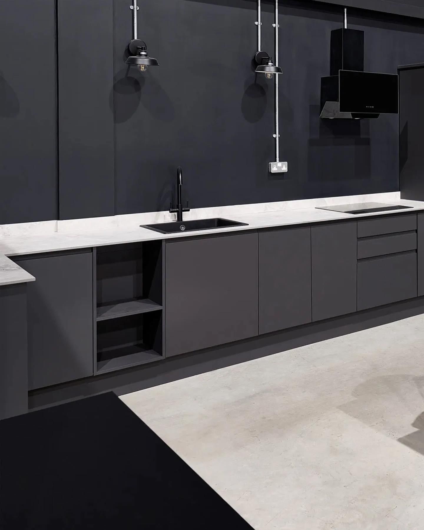 a kitchen with black cabinets and white counter tops