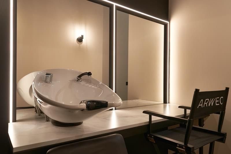 a hair salon with a sink and a director 's chair .