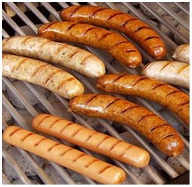 A bunch of sausages are cooking on a grill