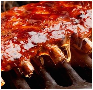 A close up of ribs cooking on a grill