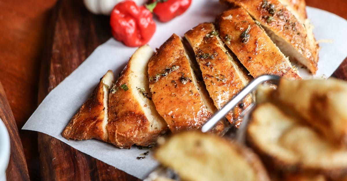 A plate of food with chicken and potatoes on a wooden table.