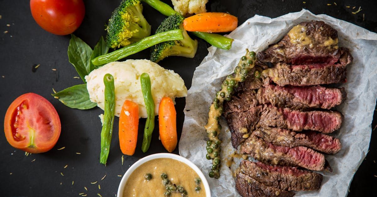 There is a plate of steak and vegetables on a table.