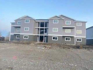 A man is standing on a ladder on the side of a building