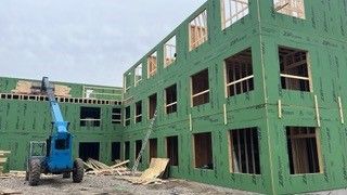A group of construction workers are working on a wooden structure