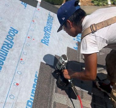 A man is working on a roof with a tool