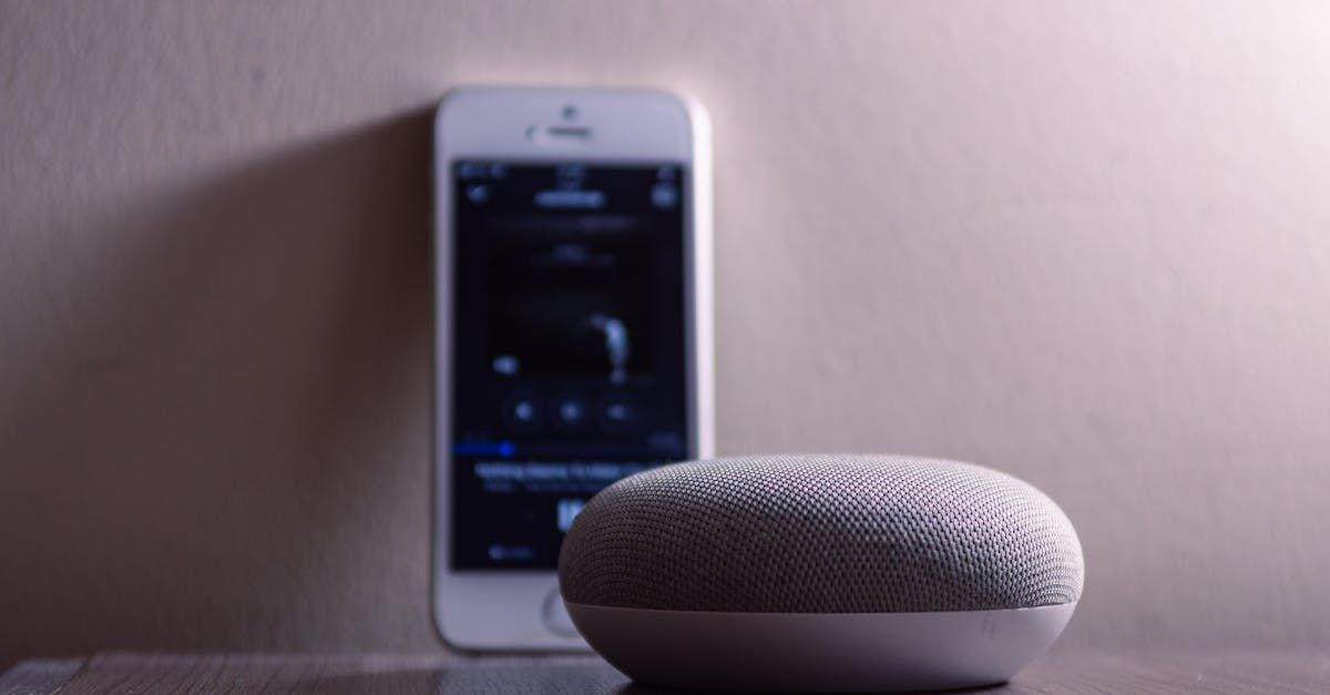 A small speaker is sitting on a table next to a cell phone.