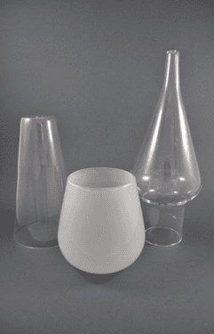 Tre paralumi in vetro trasparente su sfondo grigio. Uno è satinato.