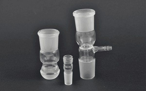 Vetreria: adattatori e un adattatore per il vuoto su sfondo nero.