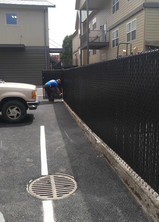 Worker installing the black steel wire fence - Vancouver, WA - DJ Fence Service