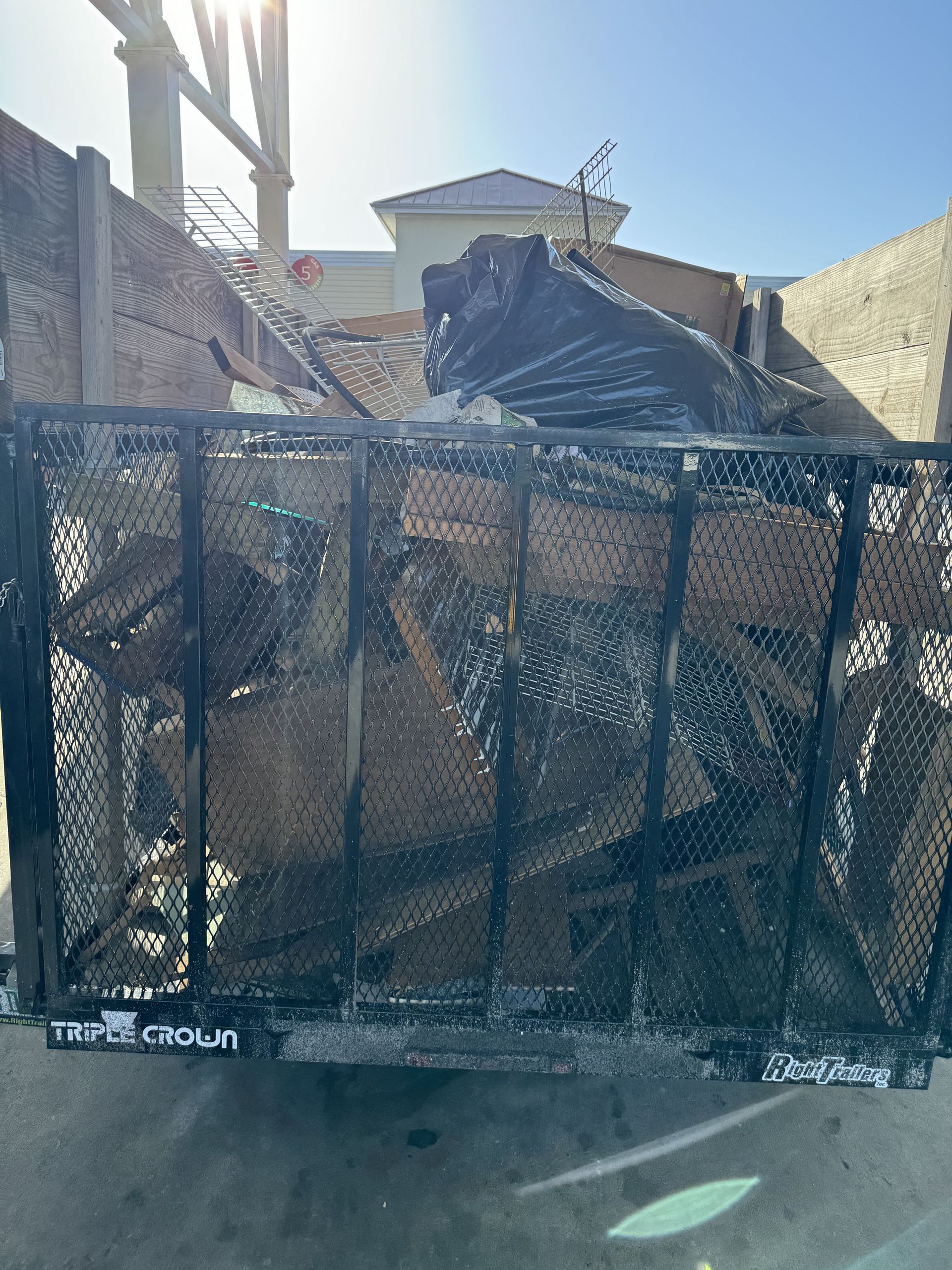A large pile of wood is sitting in a dumpster.