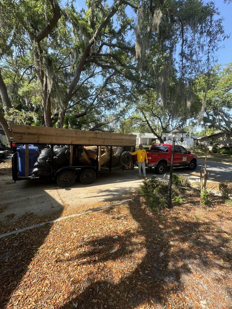 A red truck is parked in a driveway next to a trailer.