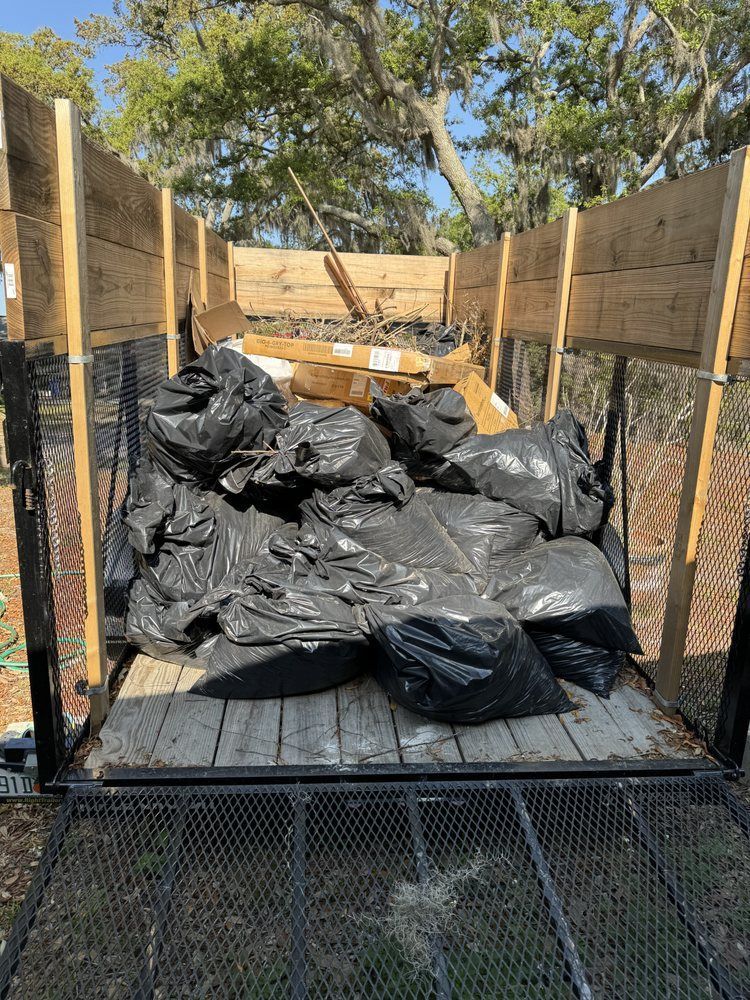 A trailer filled with trash bags and wooden boards.