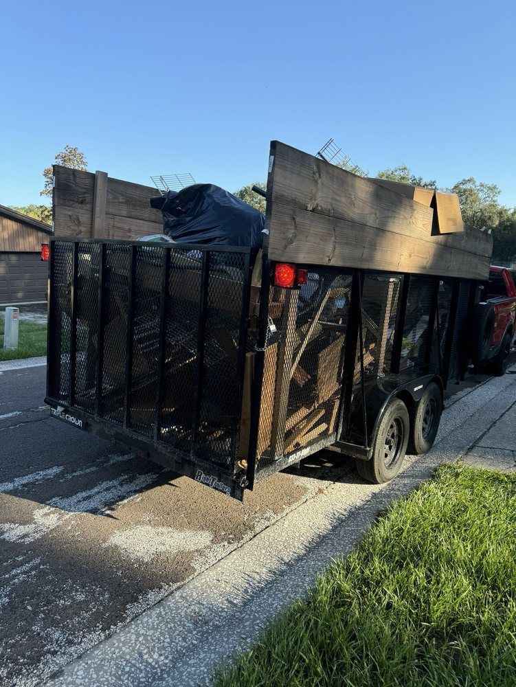A trailer is parked on the side of the road next to a truck.