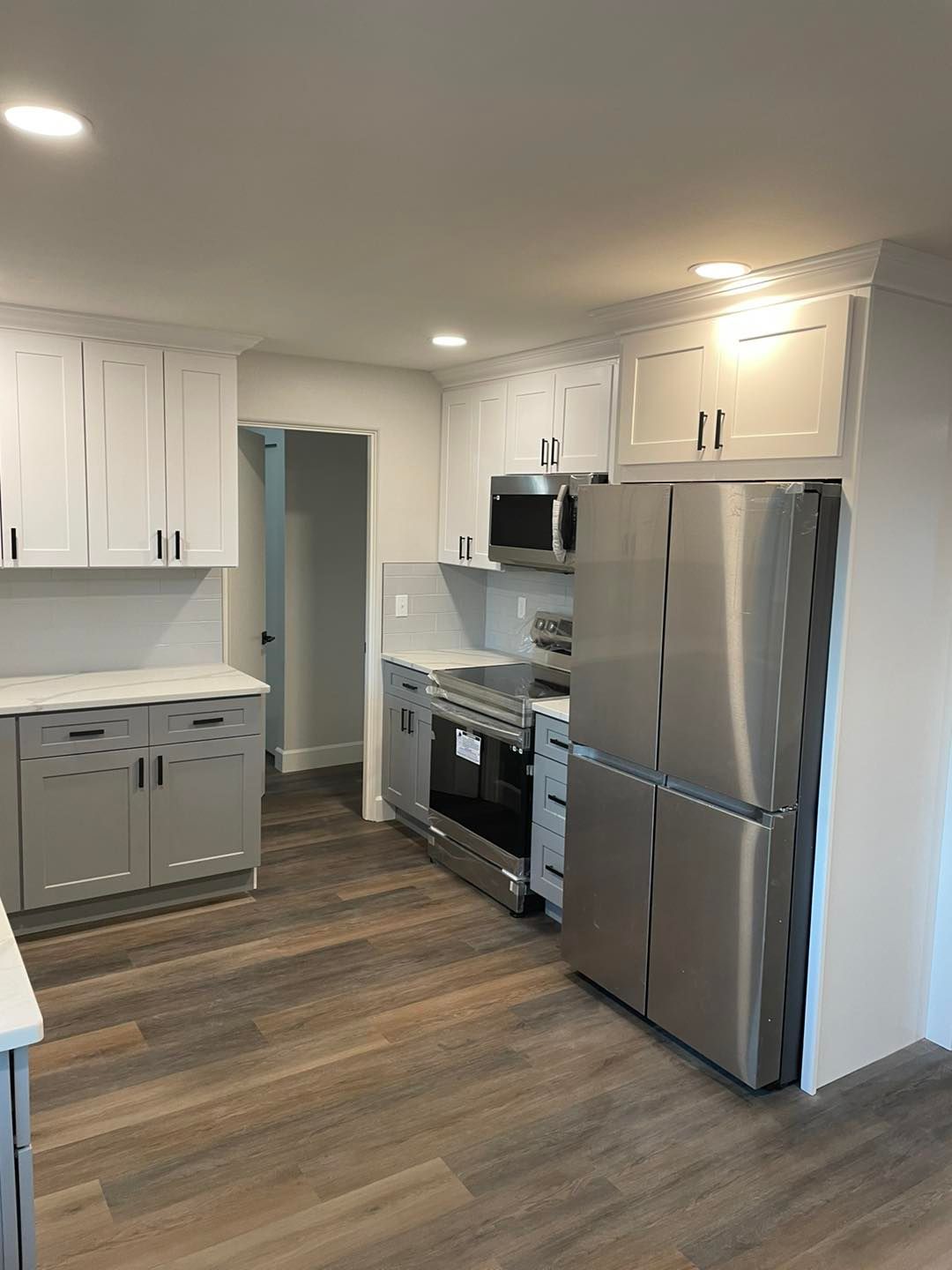 A kitchen with stainless steel appliances and white cabinets.