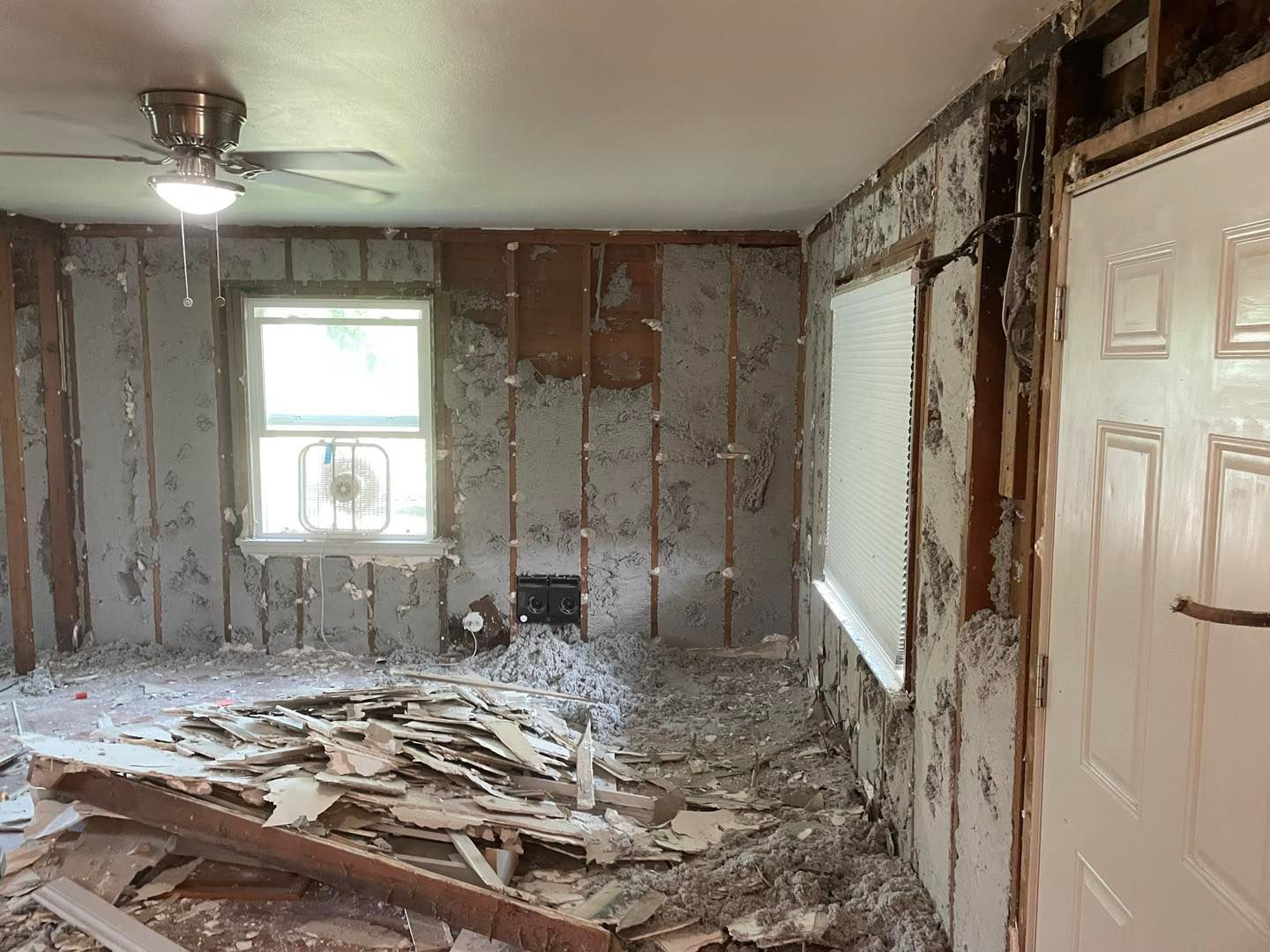A room that is being remodeled with a ceiling fan.