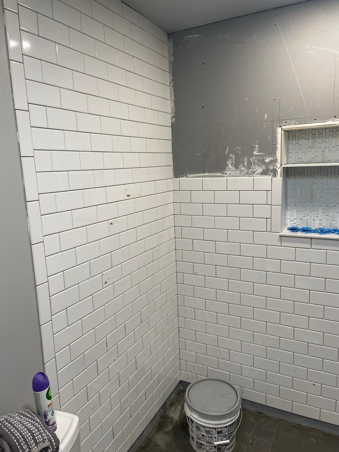 A bathroom with white subway tiles and a toilet.