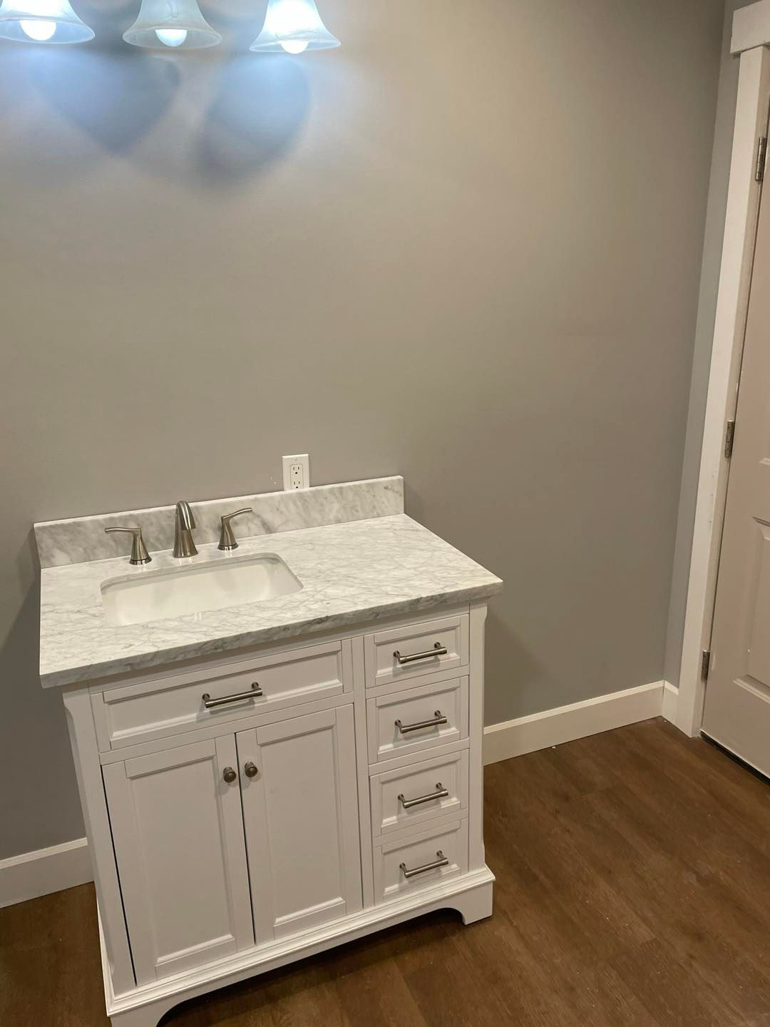 A bathroom with a white vanity and a sink.