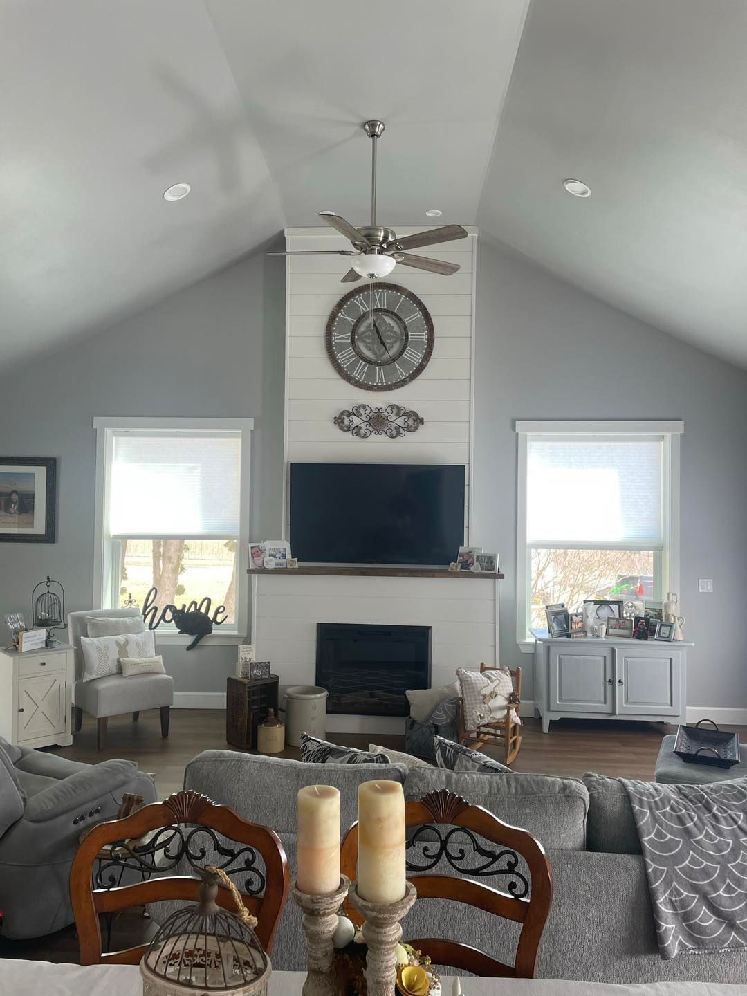 A living room with a fireplace and a clock on the wall.