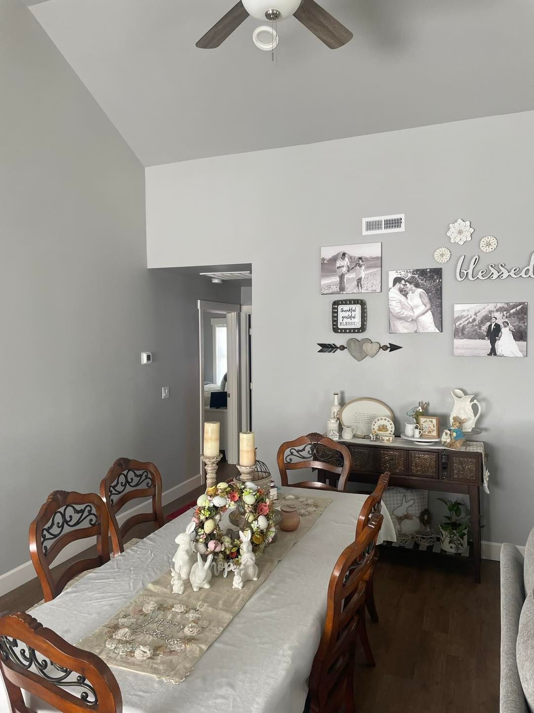 A dining room with a long table and chairs and a ceiling fan.