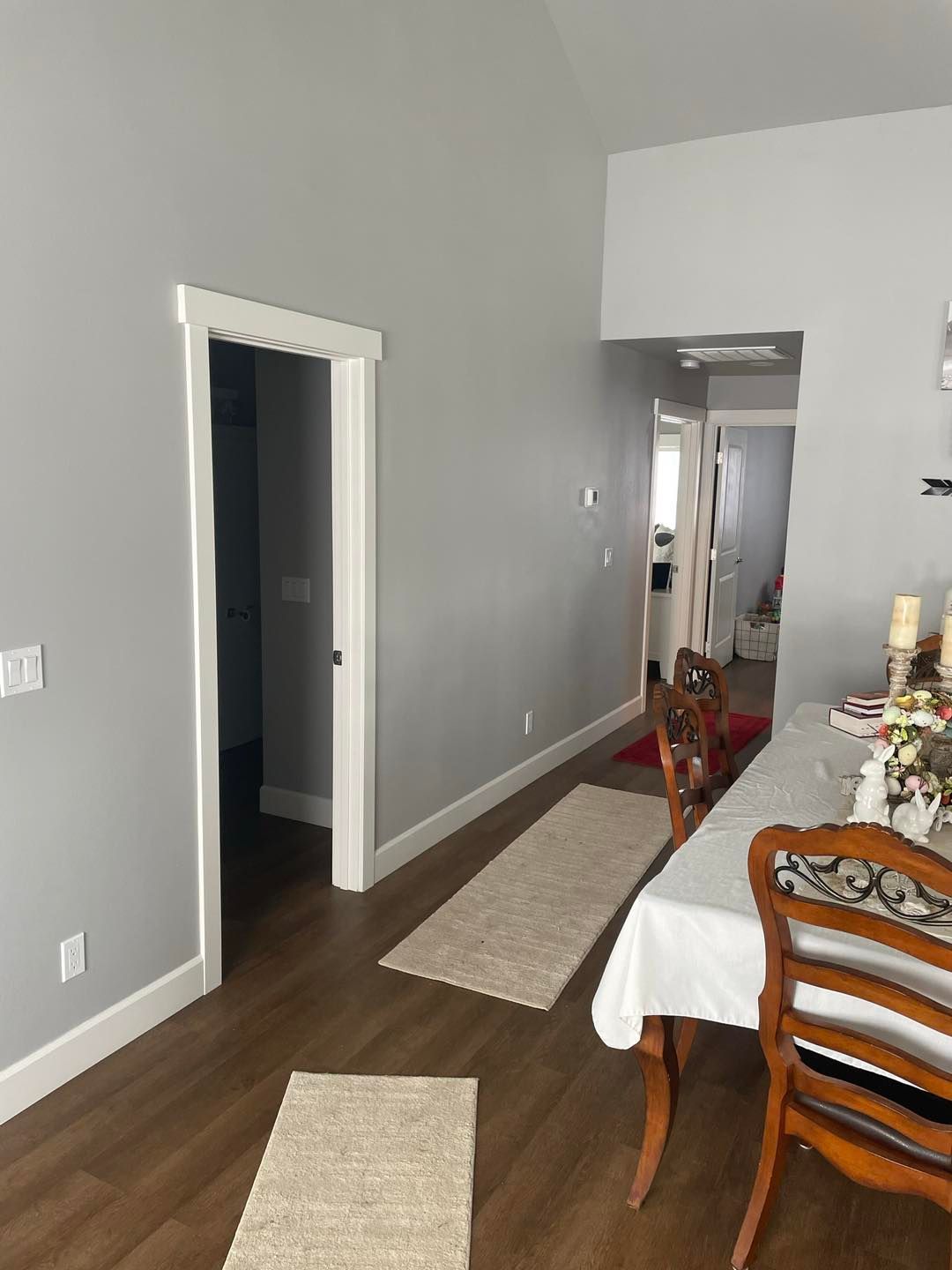 A dining room with a table , chairs and a rug.