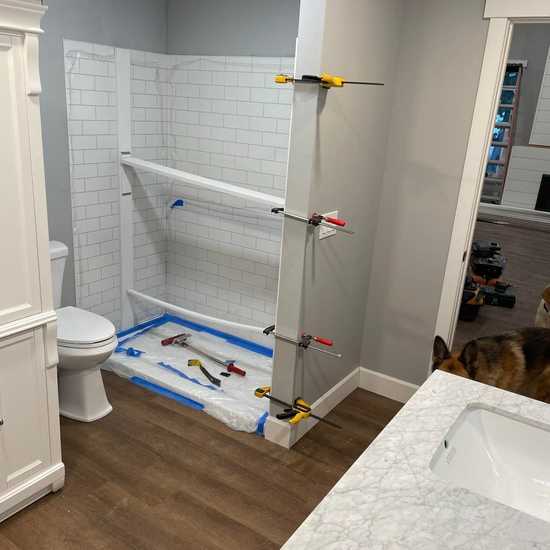 A bathroom with a toilet , sink and shower being remodeled.