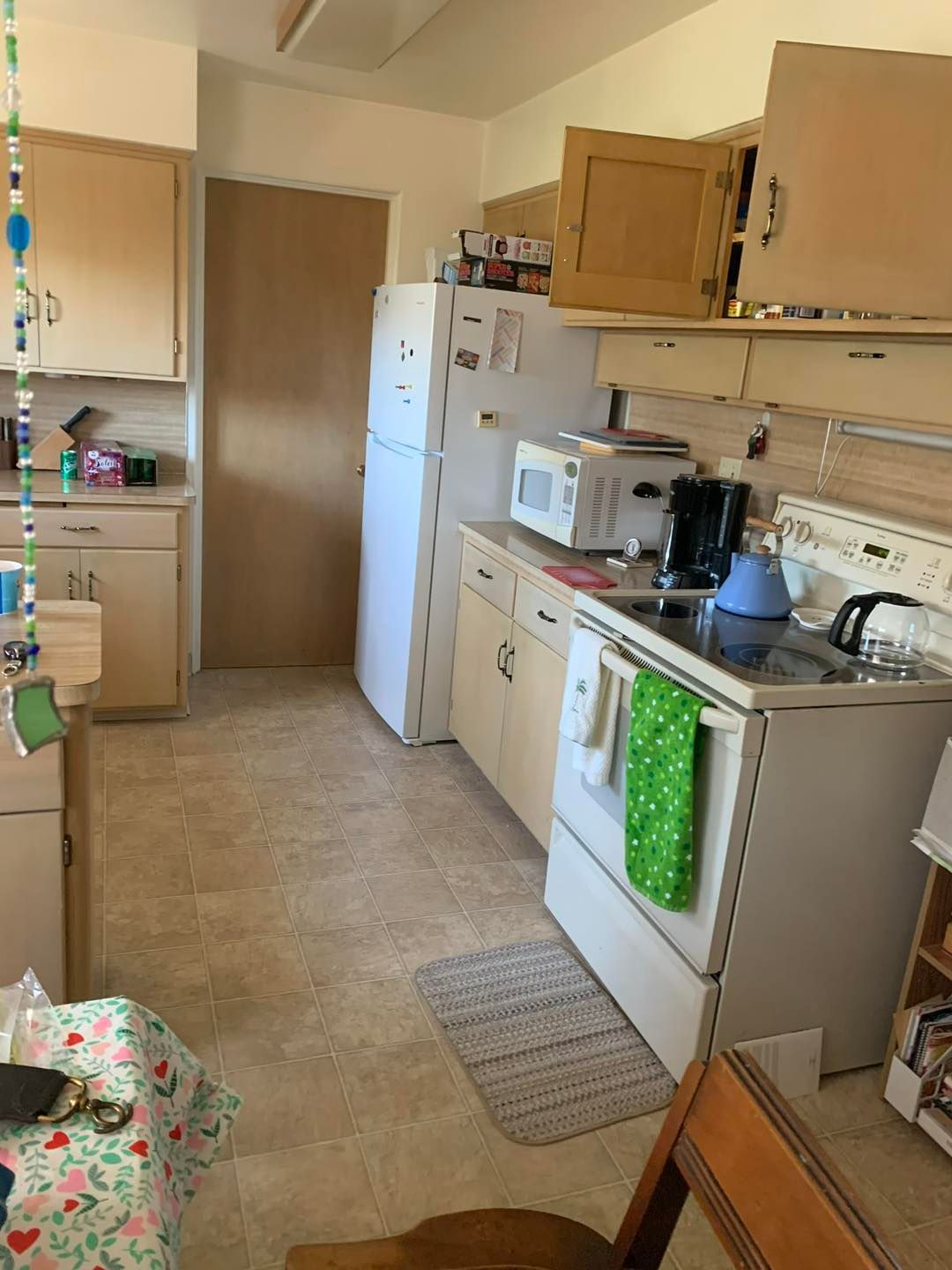 A kitchen with a stove , refrigerator and microwave