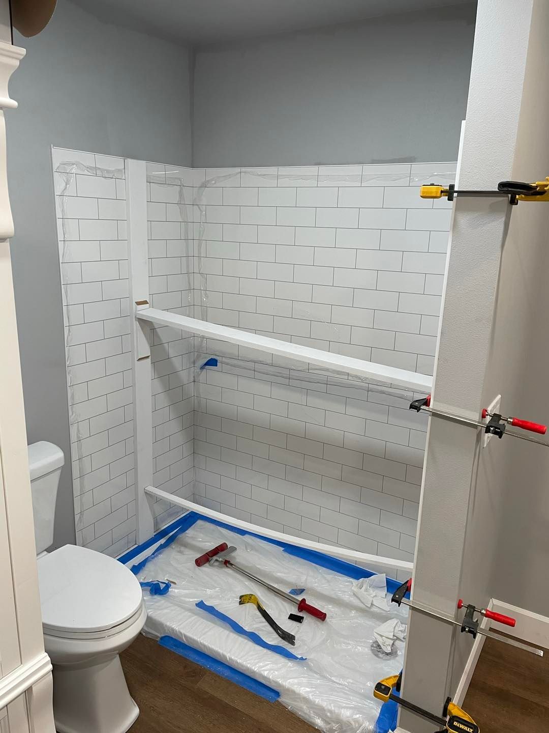 A bathroom with a toilet and a shower being remodeled.