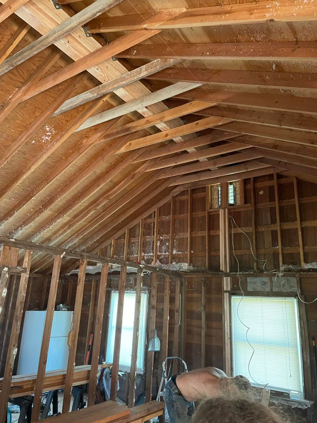 A man is working on the ceiling of a house under construction.