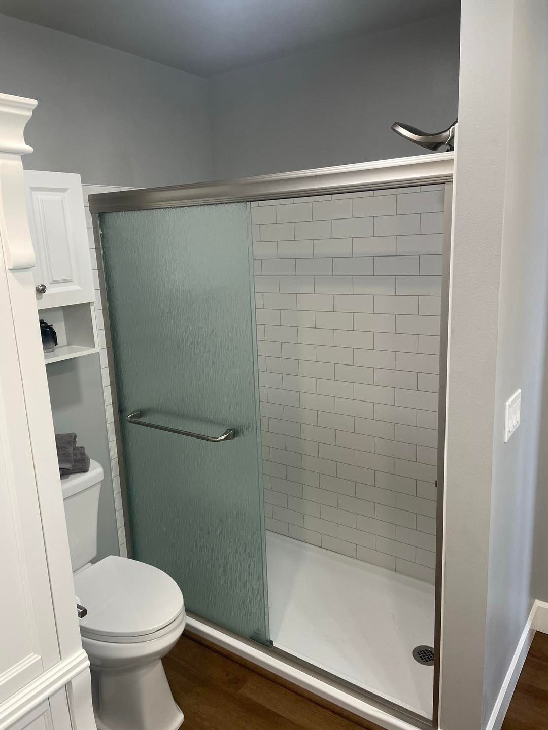 A bathroom with a toilet and a walk in shower.