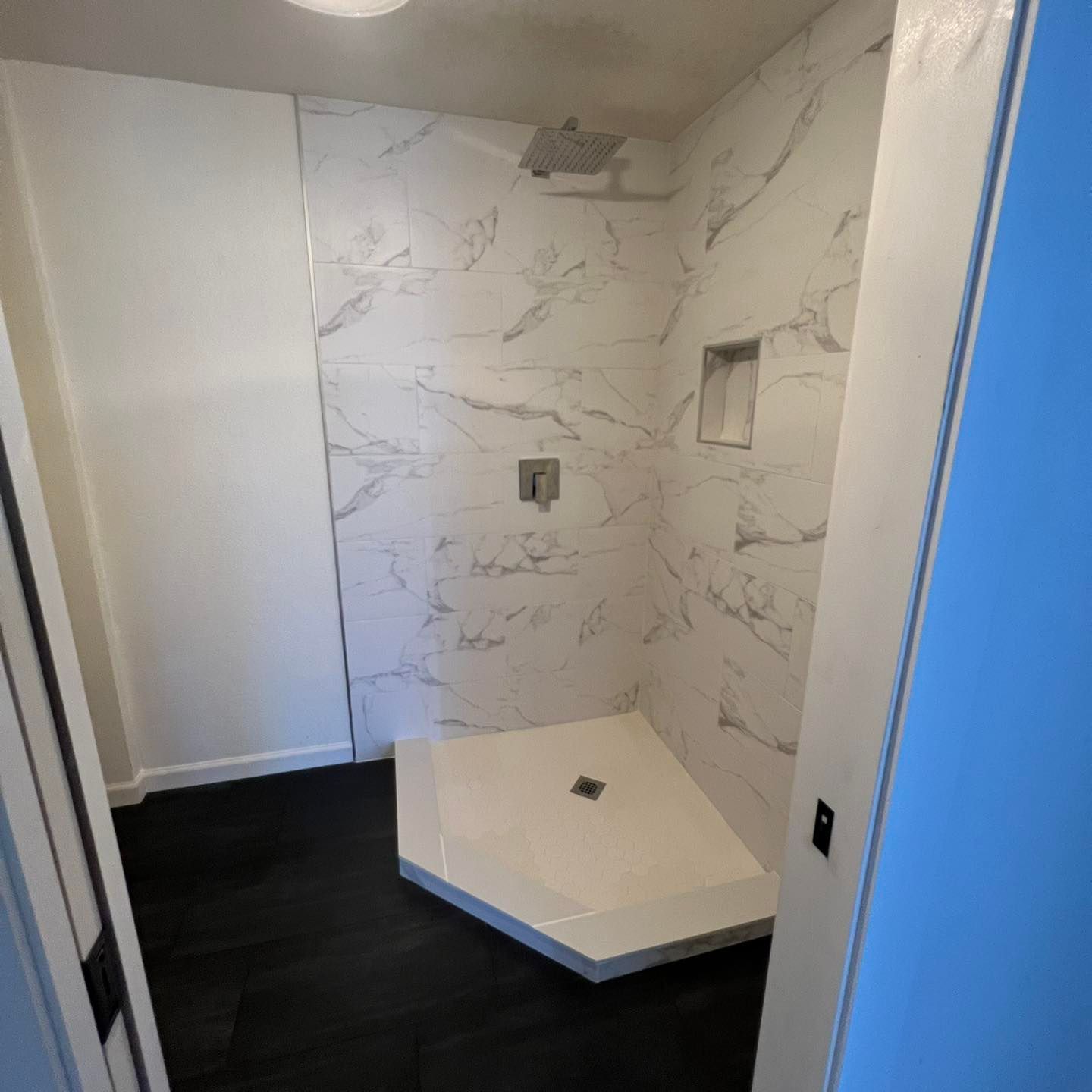 A bathroom with marble tiles and a walk in shower