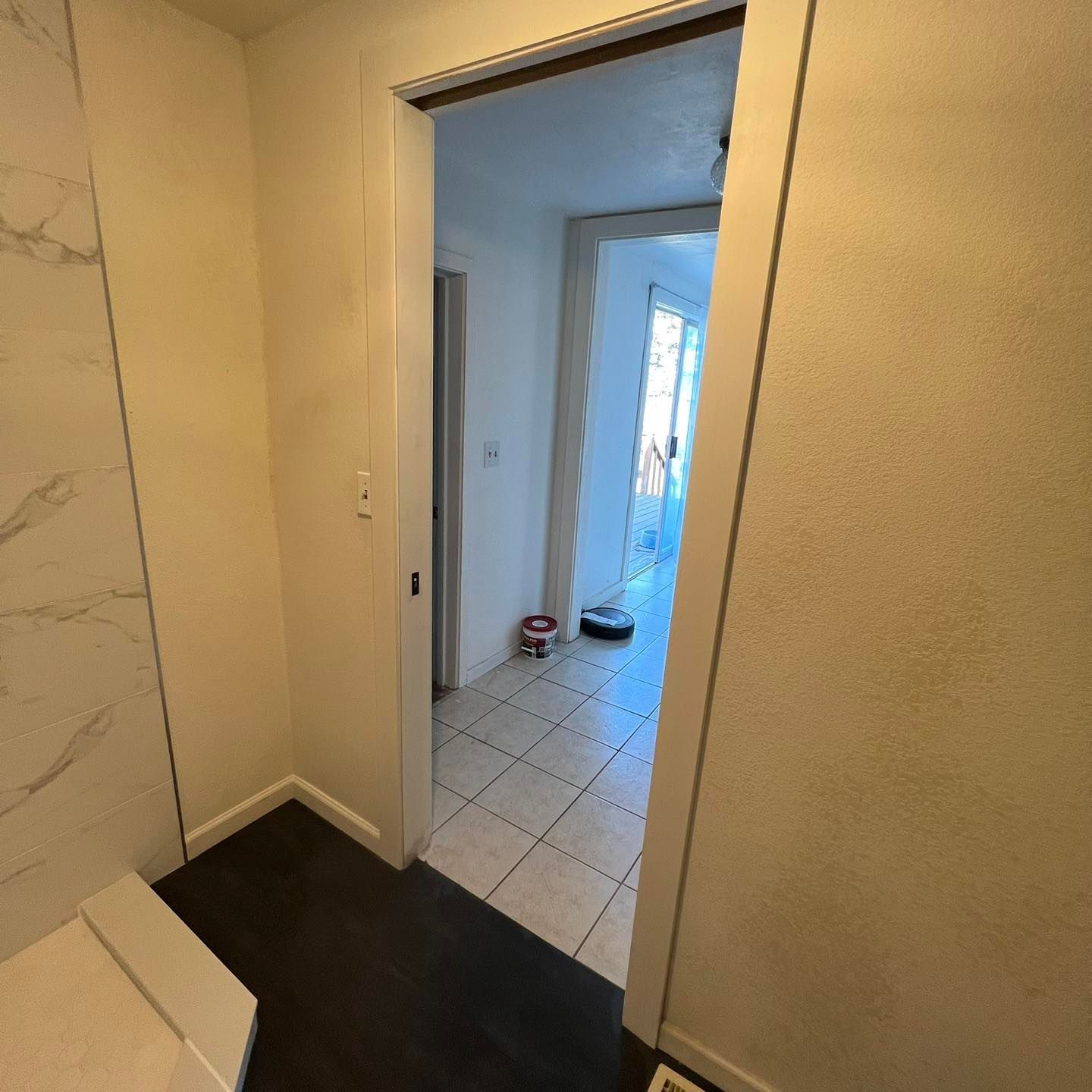 A bathroom with a sliding door that leads to a hallway