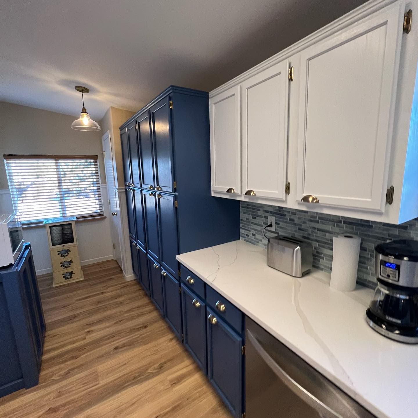 A kitchen with blue cabinets and white counter tops