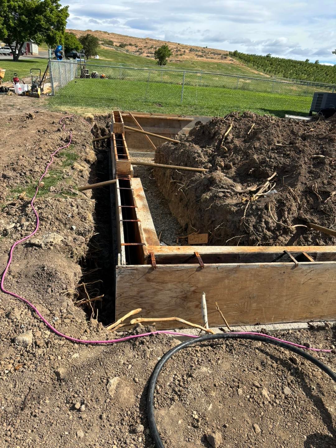 A concrete wall is being built in a dirt field.