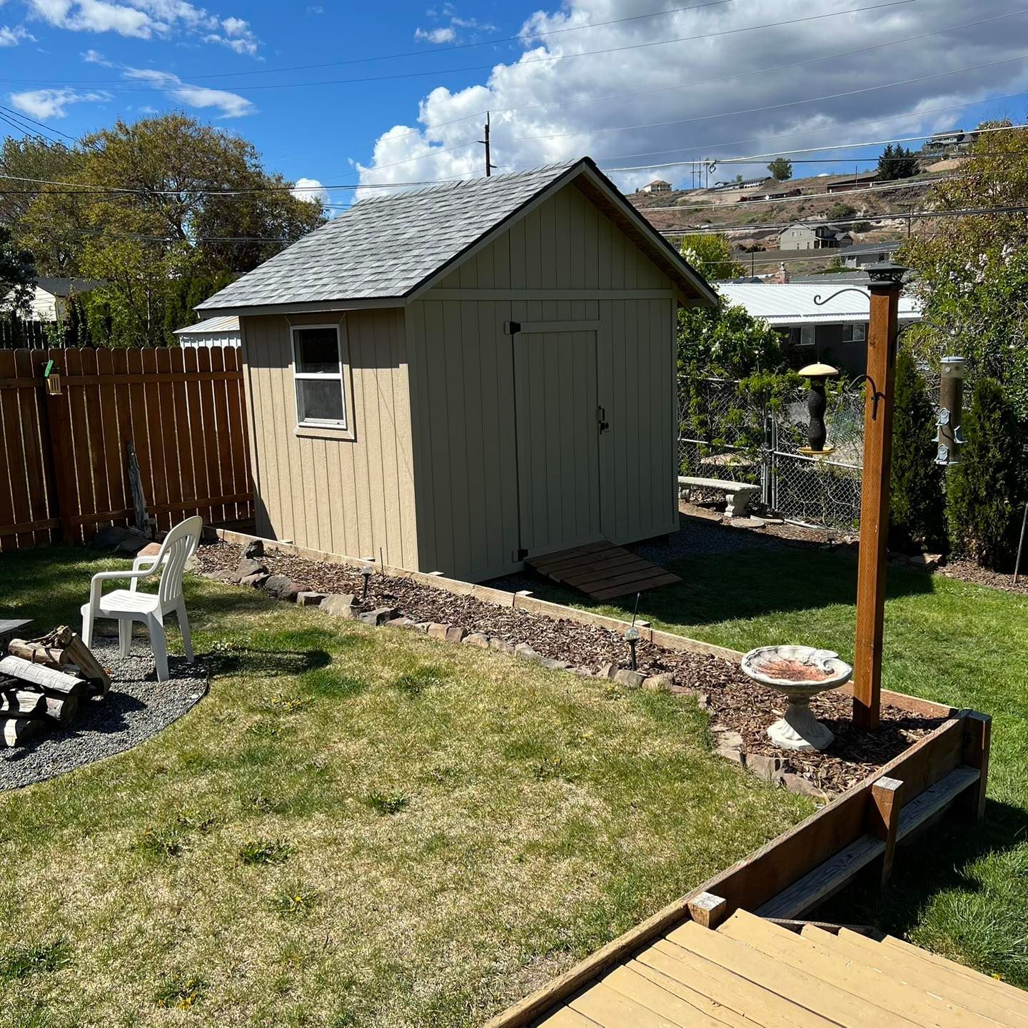 A small shed sits in the middle of a lush green yard
