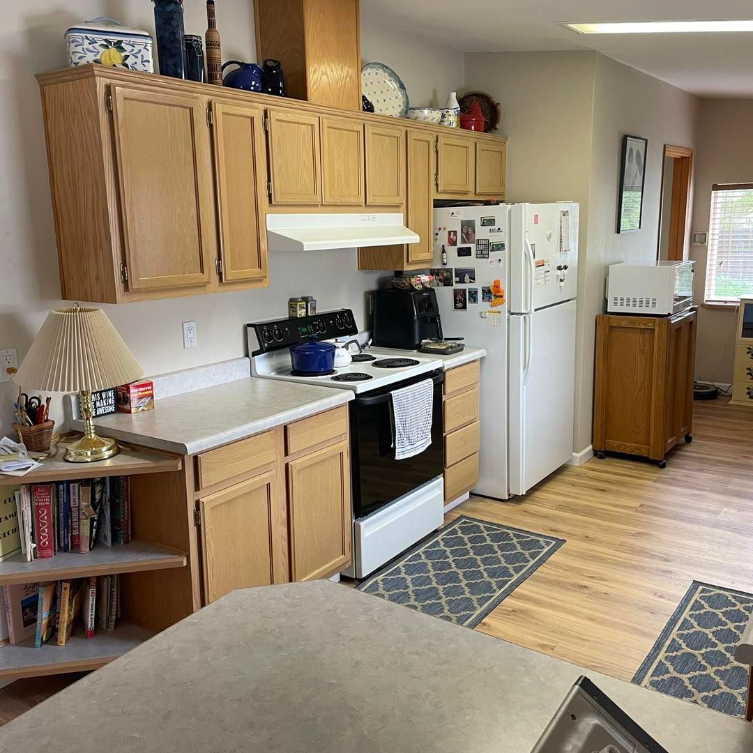 A kitchen with a stove , refrigerator , and cabinets