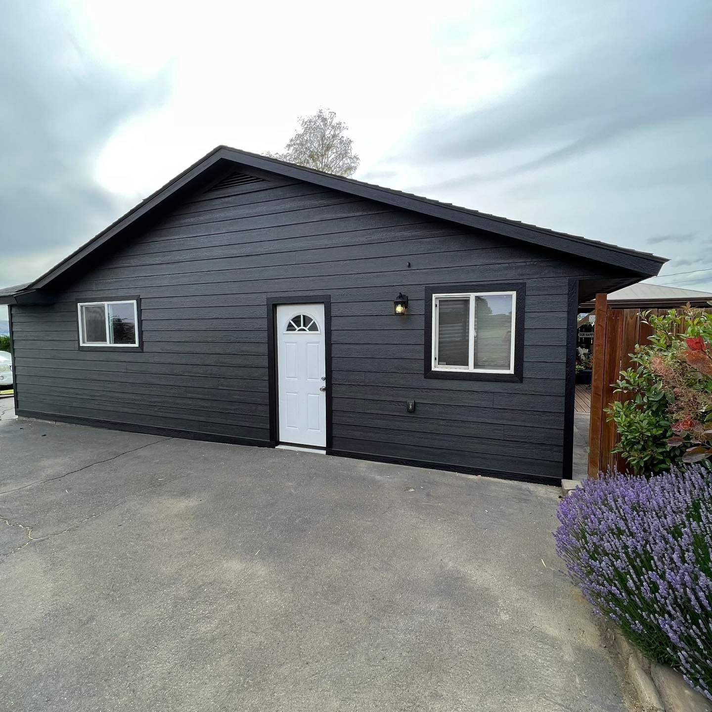 A small black house with a white door and windows.