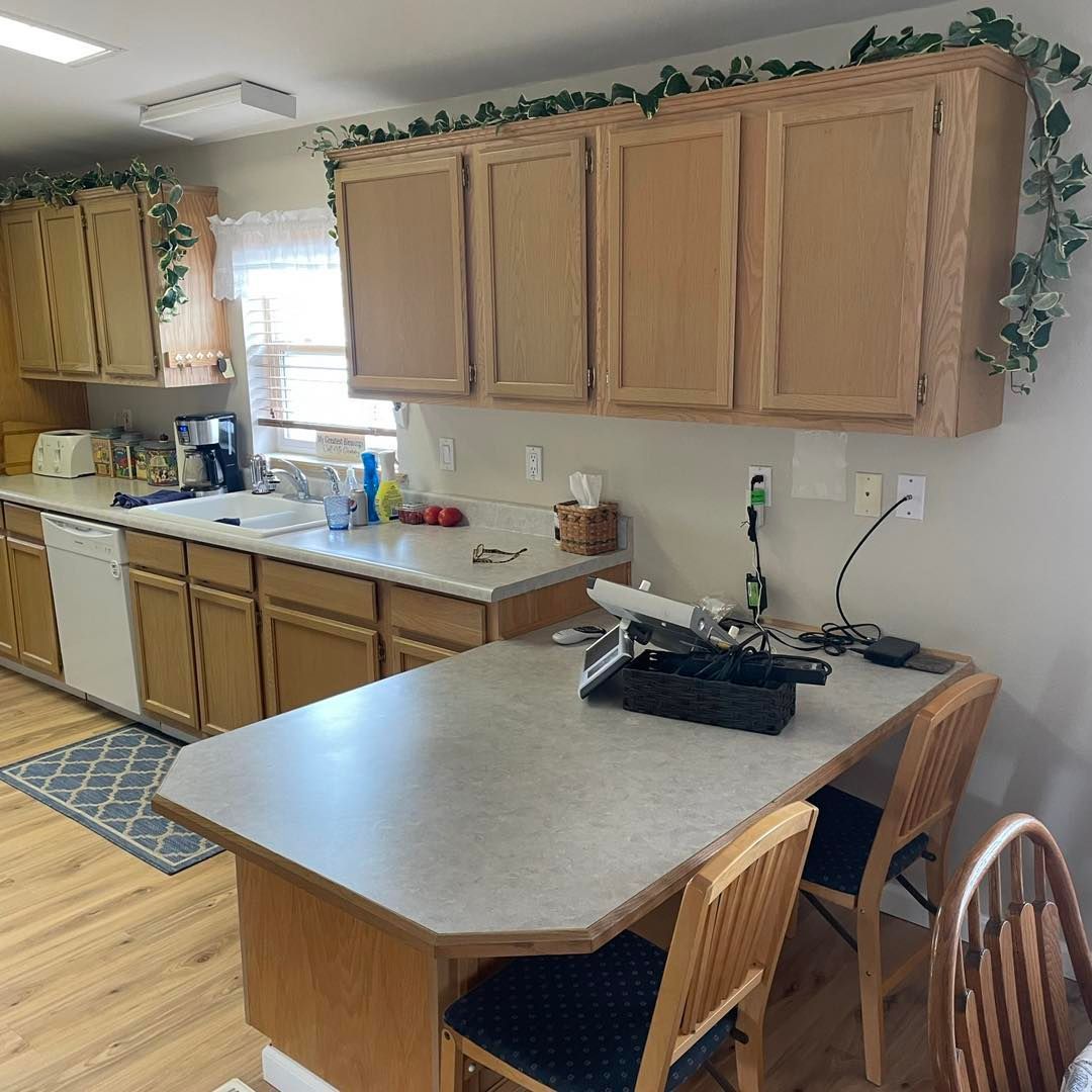 A kitchen with wooden cabinets and a large table