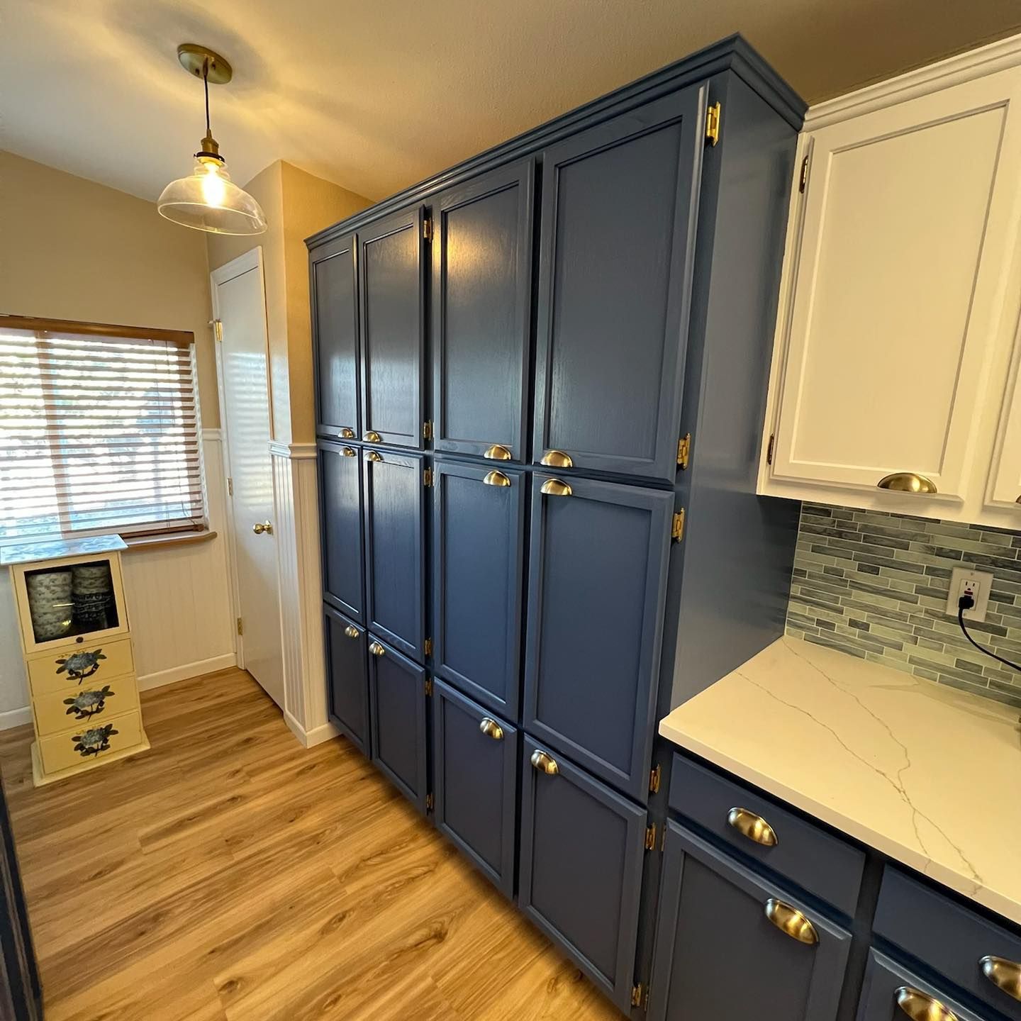 A kitchen with blue cabinets and white cabinets