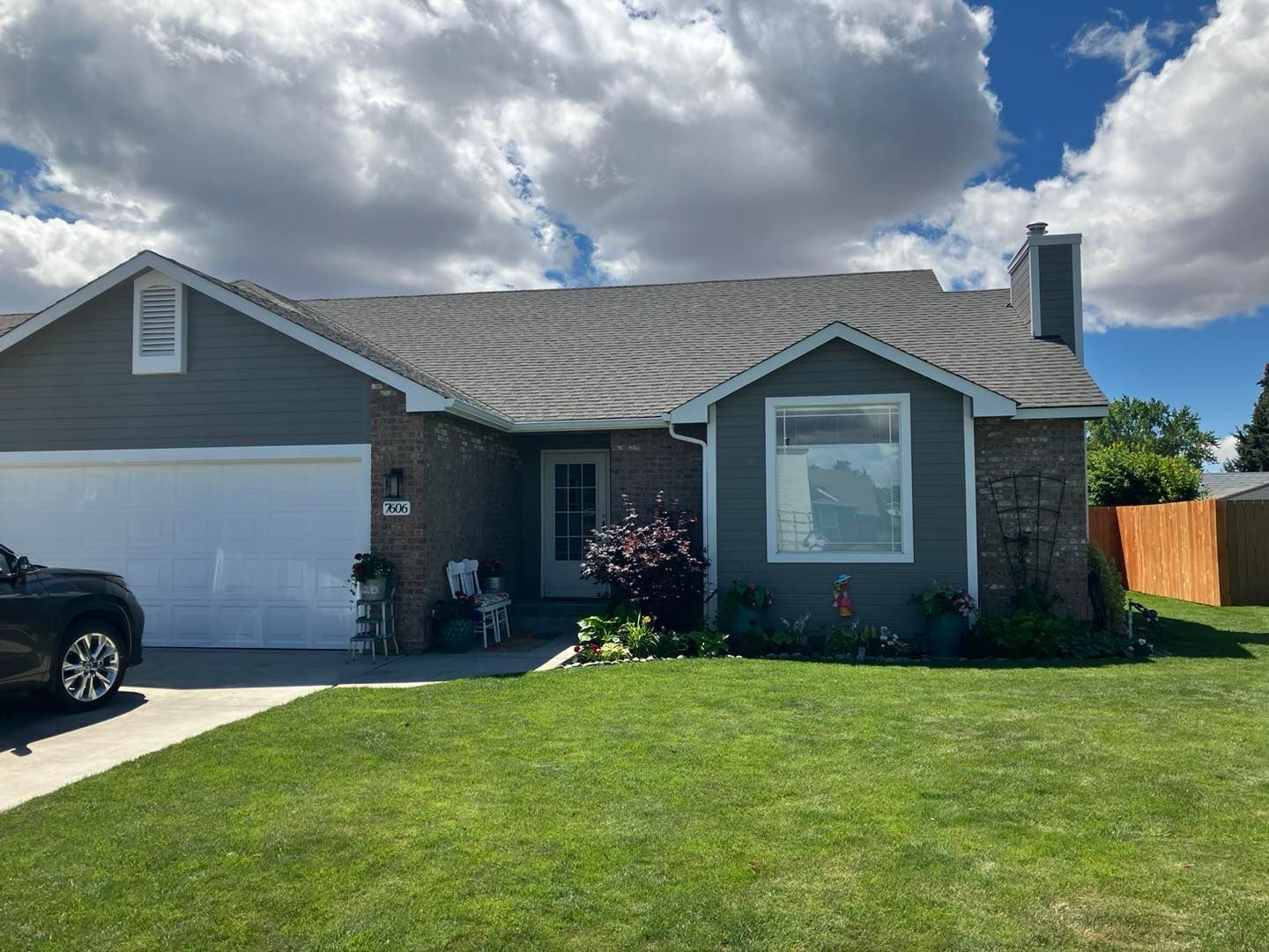 A house with a car parked in front of it on a sunny day.