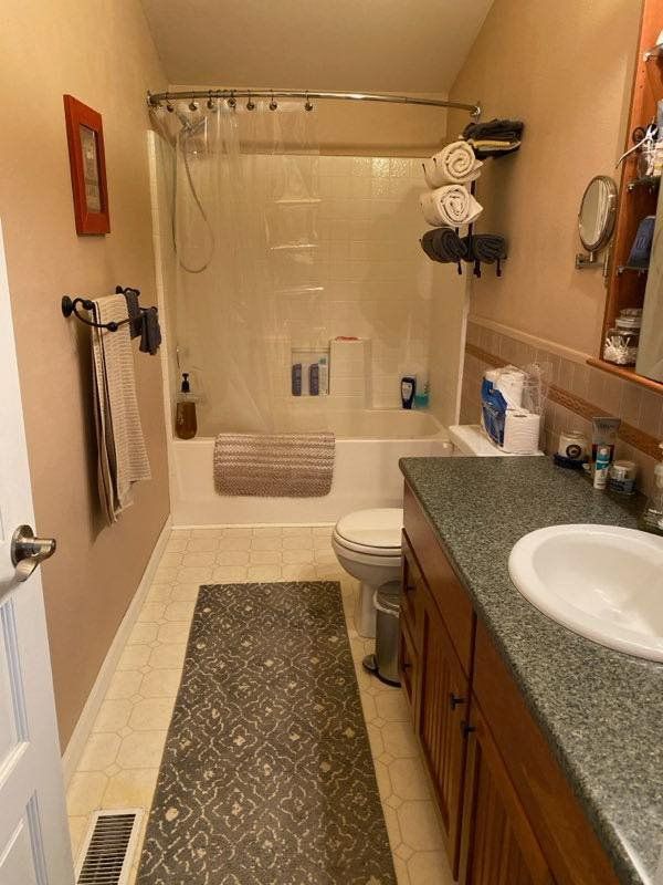 A bathroom with a toilet , sink , and shower.