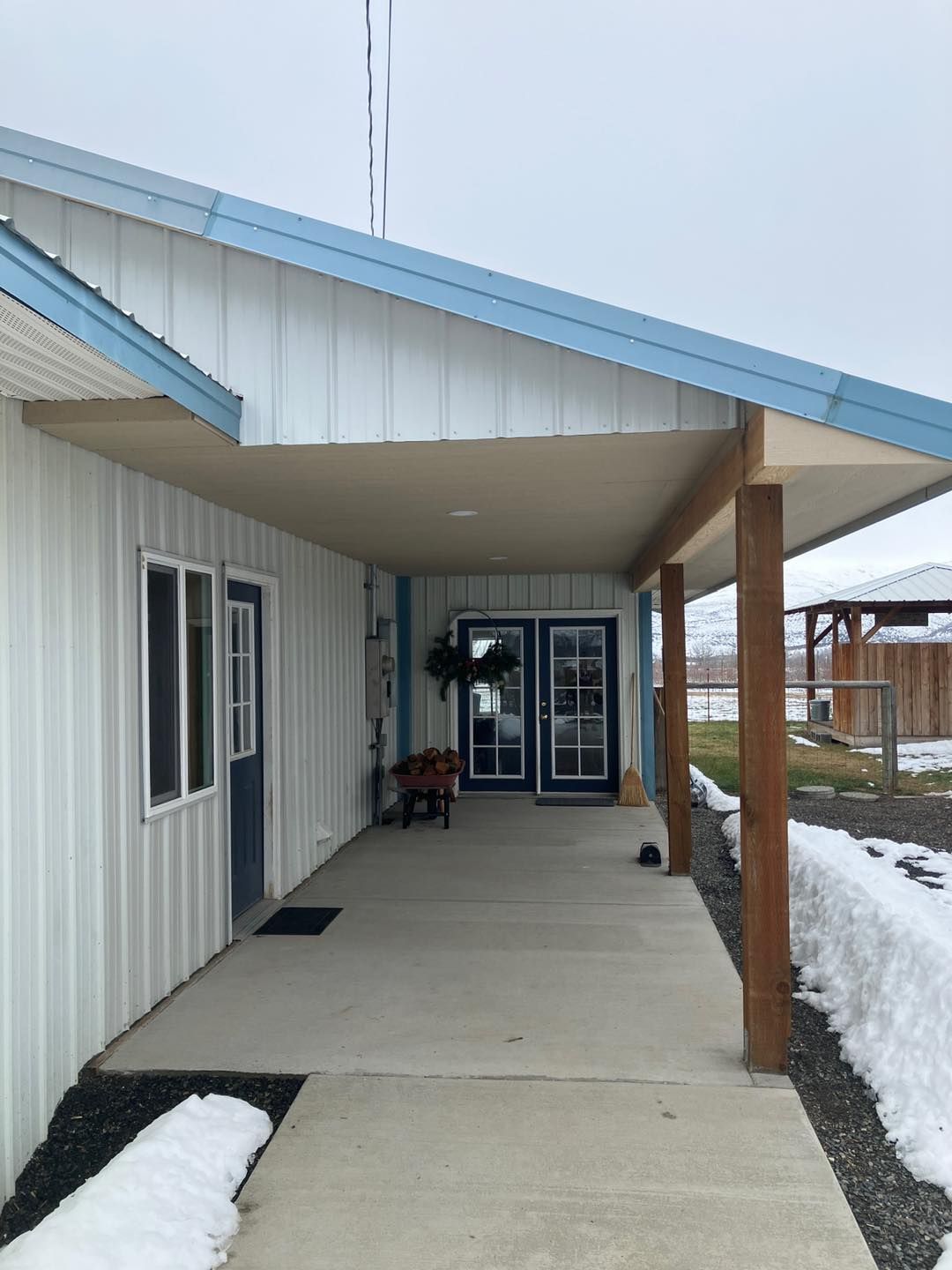 A white house with a blue roof and a porch